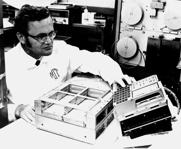 Eldon Hall inspects an AGC display and keyboard (DSKY).